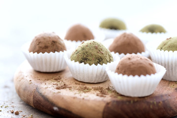 Obraz na płótnie Canvas Homemade healthy vegan chocolate truffles rolled cocoa and matcha powder