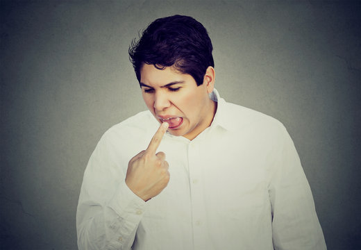 Man sticking finger in mouth about to throw up something sucks