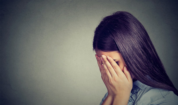 Side Profile Of A Sad Woman Covering Her Face With Hands