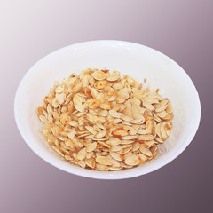 Plate with dried white sunflower seeds isolated on a gray background.
