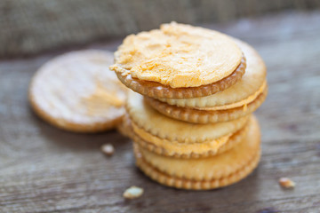 Crackers with cream on wooden background
