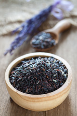Rice berry in a bowl on wooden background