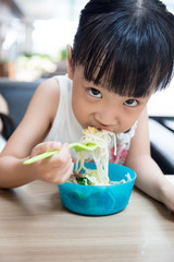 Asian little Chinese girl eating beef noodles