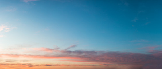 Beautiful sunset sky in orange-pink-blue tones. Panorama