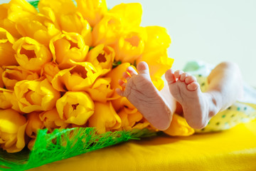 Obraz na płótnie Canvas newborn baby. The legs of a newborn with flowers. Concept. Family. Birth.
