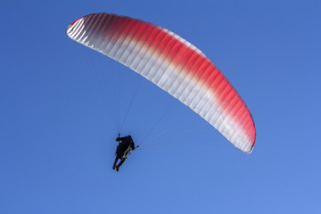 Paraglider flying in the blue sky as background