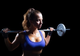 Female athlete with weights looking up against black background