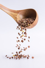 Spoon of lentil falling on a white background