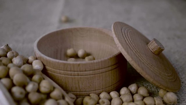 The wooden bowl is filled with chickpeas. Slow motion. Closeup