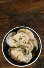 Meat dumplings - russian pelmeni, ravioli with meat on a wooden background. with copy space. top view