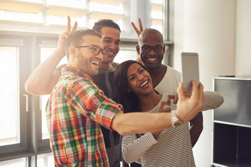 Smiling office workers taking selfie with horns