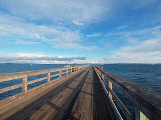 Wooden fishing pier extending from the shore into the ocean. Sidney BC, Vancouver Island