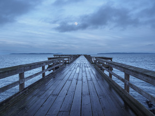 Fototapeta premium Wooden fishing pier extending from the shore into the ocean. Sidney BC, Vancouver Island