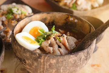 Low key of image of Meat Noodle with egg in a bowler bowl on wooden background. Thai Noodle small...