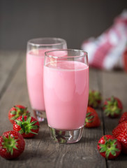 Strawberry smoothie with fresh strawberry on wood table.