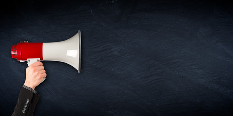 business hand with red gray megaphone bullhorn on empty slate panorama background / Hand im Anzug...