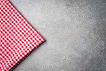 Red tablecloth on gray stone table. Close up