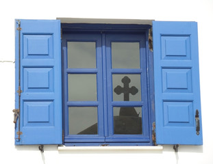 Obraz premium Reflection of the cross of Orthodox church dome top on the window glass, Santorini Island, Greece 