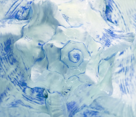 Spiral and texture of Branched Murex sea shell in light and vibrant blue color, closed up for background, pattern 