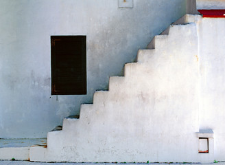 simplistic white staircase with dark window
