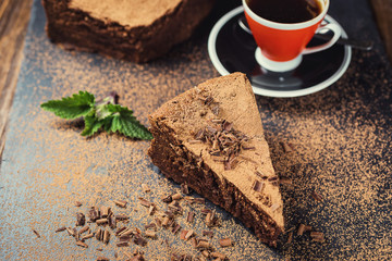 chocolate cake with Candies and cup of coffee,Chocolate cake with a cut piece and blade on gray background,closeup,Dark chocolate cake,vegan chocolate cake,Tasty chocolate cake on wooden background