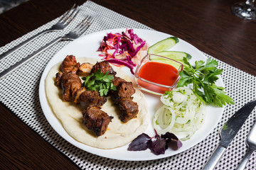 Kebab on pita bread with vegetables, onions and sauce.