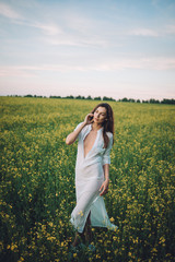 Fototapeta premium Girl walking in the field at sunset