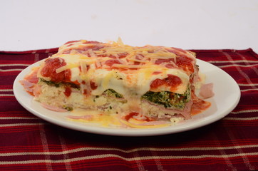 Lasaña con queso, salsa pomodoro y rellena de verdura espinaca y jamón