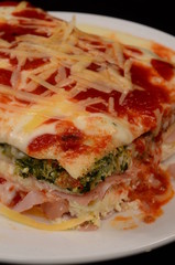 Lasaña con queso, salsa pomodoro y rellena de verdura espinaca y jamón
