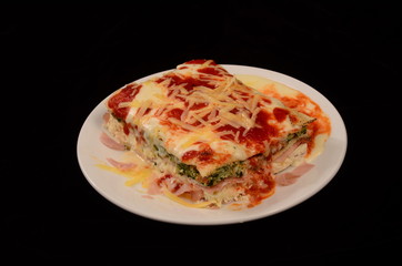 Lasaña con queso, salsa pomodoro y rellena de verdura espinaca y jamón