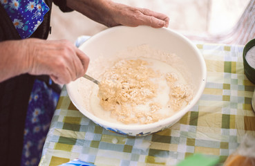 Grandmother preparing batter for pancakes