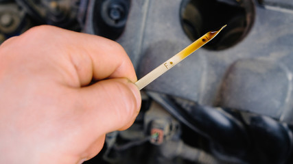 checking the oil level in a car engine
