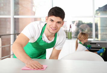 Young man cleaning kitchen table