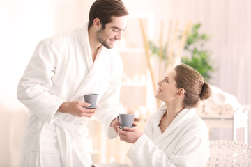 Young happy couple drinking tea in spa salon