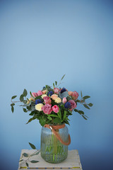 Glass vase with beautiful bouquet on color background