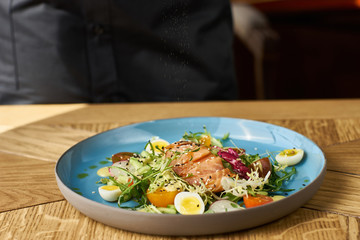 Vegetable salad with cucumber, lettuce, cherry tomatoes, salmon and eggs