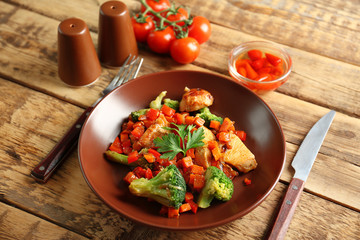 Chicken stir fry with vegetables and cutlery on table