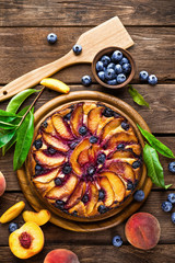 Peach cheese cake or pie with fresh blueberry on wooden rustic background, top view, closeup