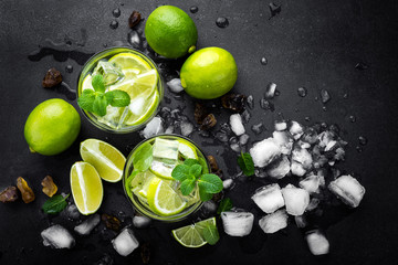 Refreshing mint cocktail mojito with rum and lime, cold drink or beverage with ice on black...