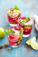 Refreshing mint cocktail mojito with rum, lime and raspberry, cold drink or beverage