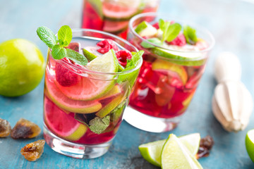 Refreshing mint cocktail mojito with rum, lime and raspberry, cold drink or beverage
