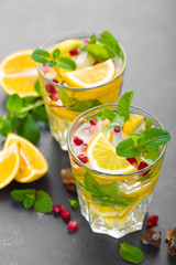 Lemon mojito cocktail with fresh mint and pomegranate, cold refreshing summer drink or beverage with ice
