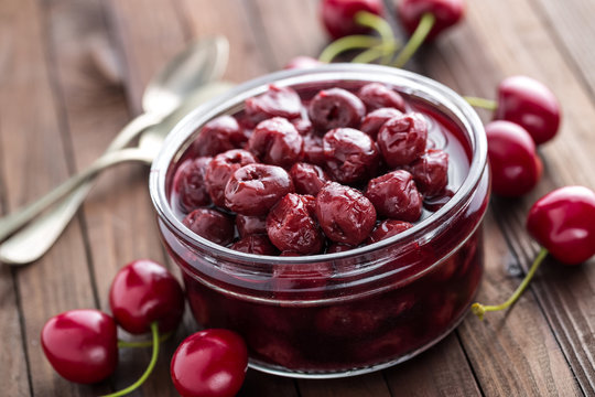 Berries Cherry With Syrup In A Glass Jar. Canned Fruit