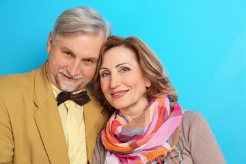 Happy senior couple on color background