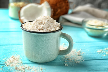 Obraz na płótnie Canvas Cup with coconut flour on wooden background