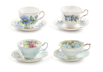 High resolution close-up of four beautiful antique tea cups with saucers isolated on a white background.