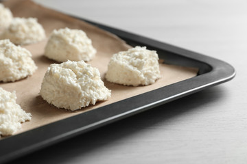Baking tray with delicious coconut macaroons on table