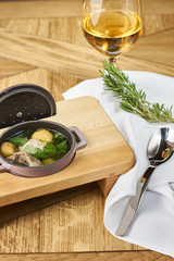 Potato soup with meatballs served on wooden table with spoon and glass of wine