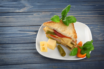 Tasty sandwich with cheese and sausage on plate