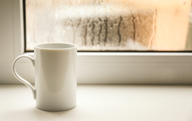 Cup of hot tea on window sill